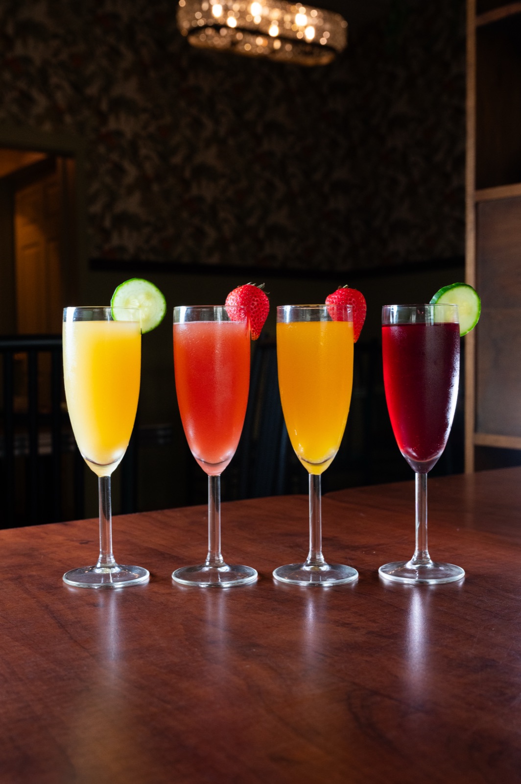 A flight of four brunch mimosas in different colours.