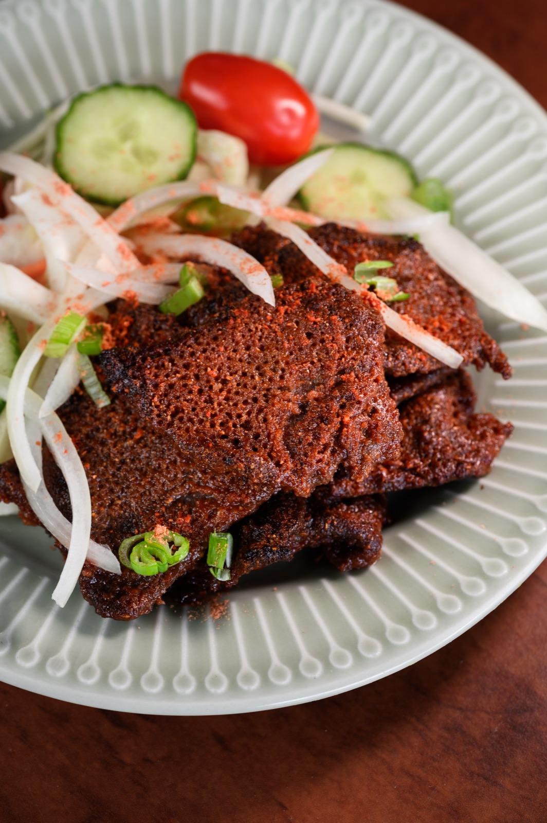 Suya — spiced grilled beef with onions and tomato.